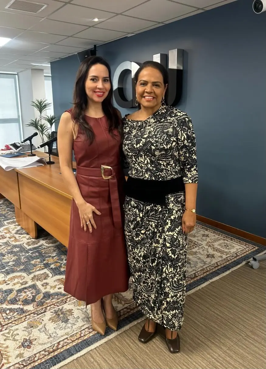 A juíza Tatyana Lopes de Araújo Borges, representante da Cemulher-MT, posa ao lado da conselheira Jaceguara Dantas. As duas estão abraçadas, em pé, olhando para a câmera, na recepção do auditório do CNJ.