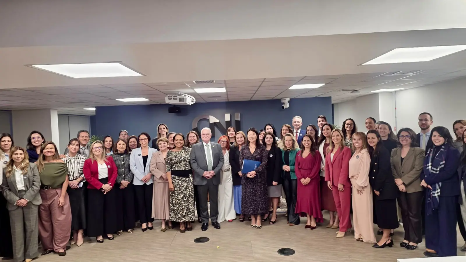 Grupo de 45 pessoas, representantes das Coordenadorias da Mulher dos Tribunais de Justiça de todo o país posa para foto. Todos estão enfileirados, olhando para a câmera e sorrindo. Ao centro está o ministro Edson Fachin. Dentre as 45 pessoas, cinco são homens. 